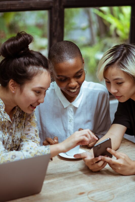 Drie vrouwen bekijken een livestream op een smartphone